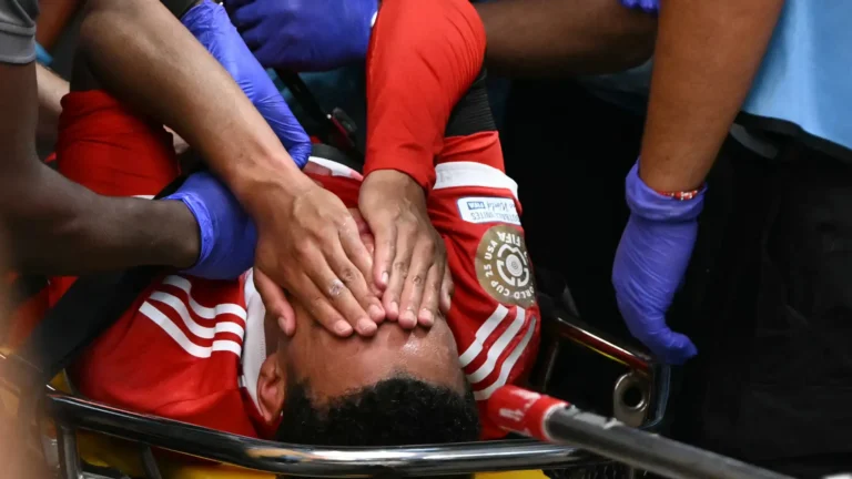 Bayern Munich midfielder Jamal Musiala injured on the field during the FIFA Club World Cup quarterfinal against Paris Saint-Germain, surrounded by medical staff and teammates at Mercedes-Benz Stadium.